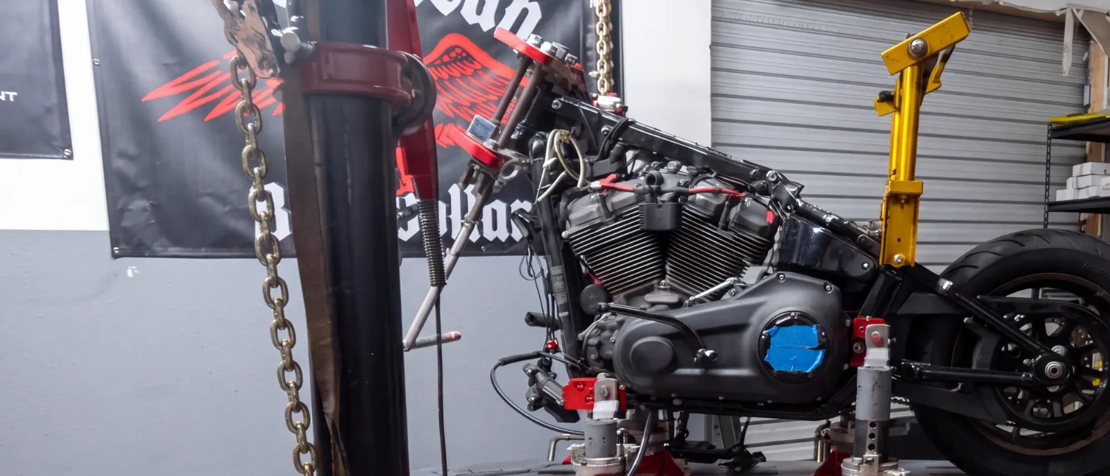 Harley-Davidson chained to a pulling tower on the frame rack at Phoenix Performance Alignment